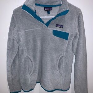Fuzzy light grey Patagonia sweatshirt. With teal outline.